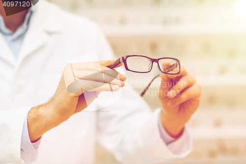 Image of close up of optician with glasses at optics store