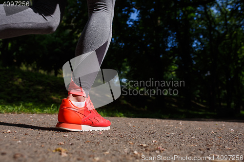 Image of young fitness woman hiker legs at forest trail