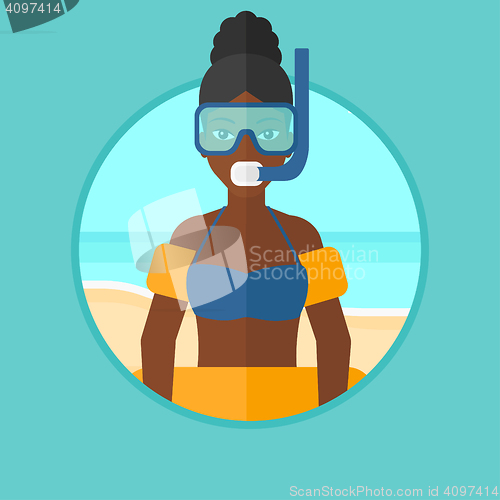 Image of Woman with snorkeling equipment on the beach.