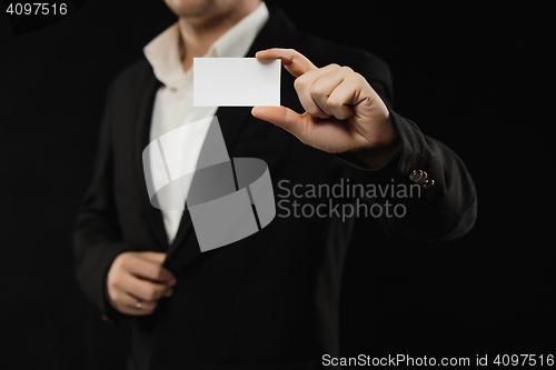 Image of The businessman in black costume showing credit card or visiting card