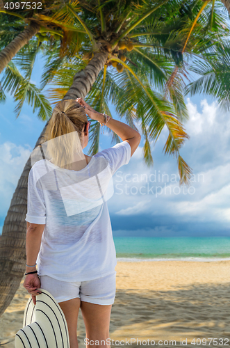 Image of portrait of young pretty woman looking to the ocean 