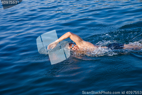 Image of Man swimming in blue water