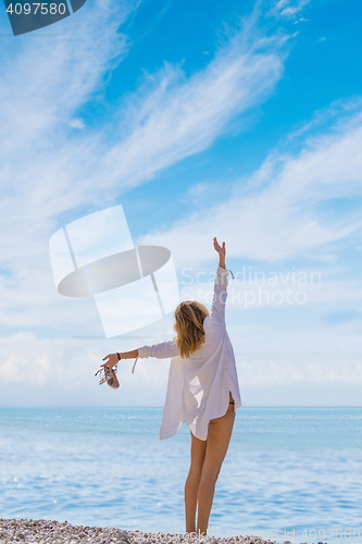 Image of portrait of young pretty woman looking to the ocean 