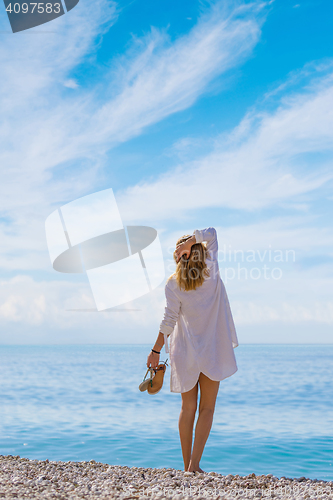 Image of portrait of young pretty woman looking to the ocean 