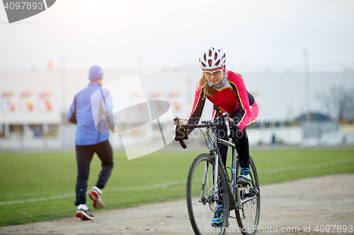 Image of Sport girl cycling in the autumn overcast weather day