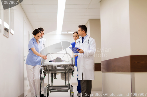 Image of medics with woman on hospital gurney at emergency