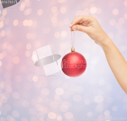 Image of close up of woman in sweater with christmas ball