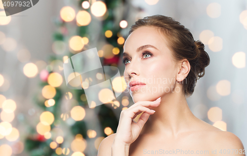 Image of beautiful woman face over christmas lights