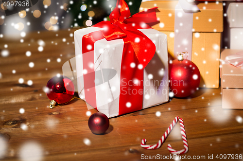 Image of gifts, candies and christmas balls on wooden board