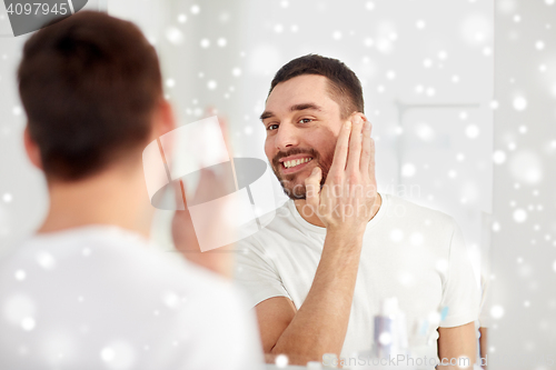 Image of happy man applying shaving foam at bathroom mirror