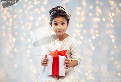 Image of smiling little girl with gift box over lights