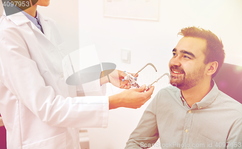 Image of optician with trial frame and patient at clinic