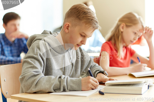 Image of group of students with books writing school test