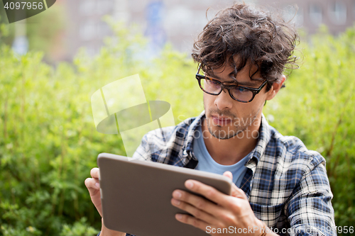 Image of man in glasses with tablet pc computer outdoors