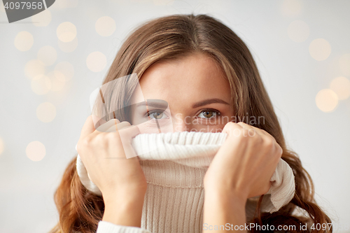 Image of young woman or teen girl pulling pullover collar