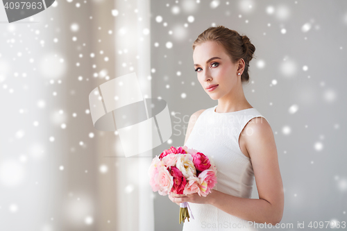 Image of bride or woman in white dress with flower bunch