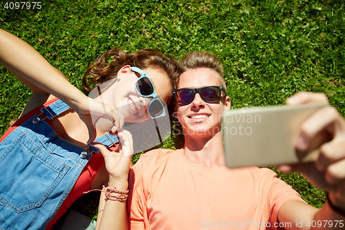 Image of happy couple taking selfie on smartphone at summer