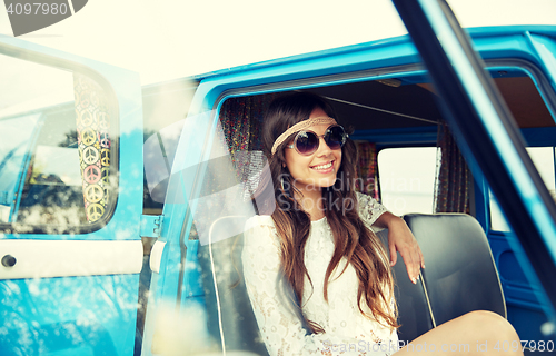 Image of smiling young hippie woman in minivan car