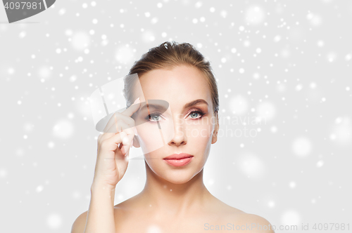 Image of beautiful woman showing her forehead over snow