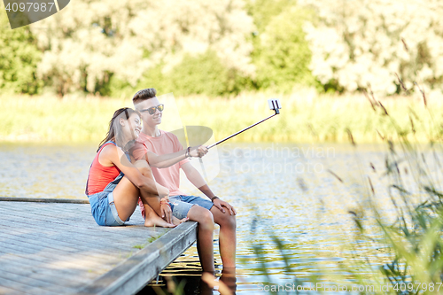 Image of happy teenage couple taking selfie on smartphone