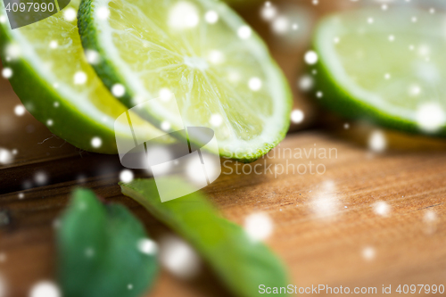 Image of close up of lime slices on wooden table