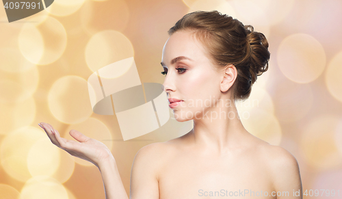 Image of woman holding something on her hand over lights