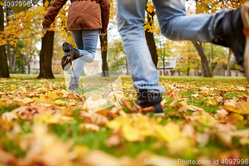 Image of young couple running in autumn park