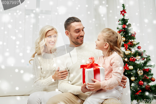 Image of happy family at home with christmas gift