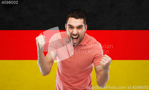 Image of angry man showing fists over german flag