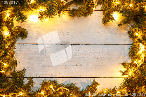 Image of Christmas template greeting card with shining garland and tree branches