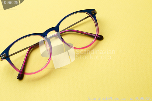 Image of Blue-pink glasses on yellow background