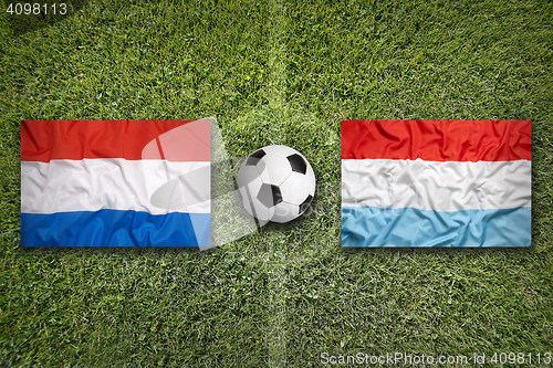 Image of Netherlands vs. Luxembourg flags on soccer field