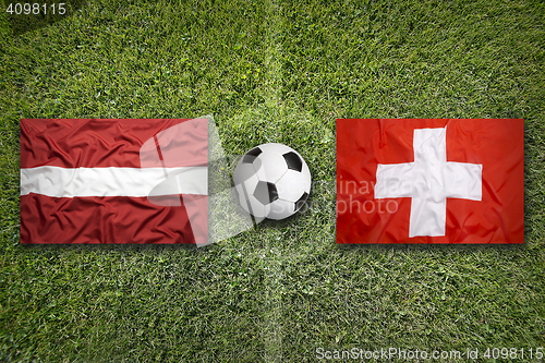 Image of Latvia vs. Switzerland flags on soccer field