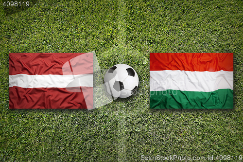 Image of Latvia vs. Hungary flags on soccer field