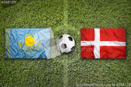 Image of Kazakhstan vs. Denmark flags on soccer field