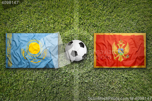 Image of Kazakhstan vs. Montenegro flags on soccer field