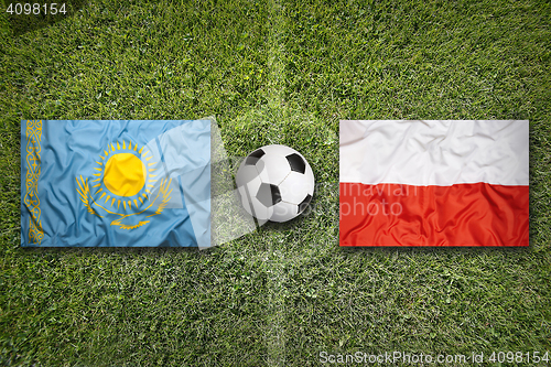 Image of Kazakhstan vs. Poland flags on soccer field