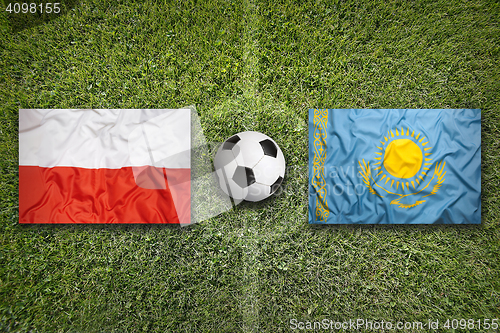 Image of Poland vs. Kazakhstan flags on soccer field