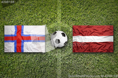 Image of Faroe Islands vs. Latvia flags on soccer field