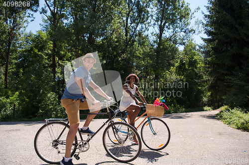 Image of Young multiethnic couple having a bike ride in nature