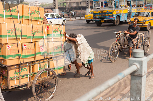 Image of Men pushing goods