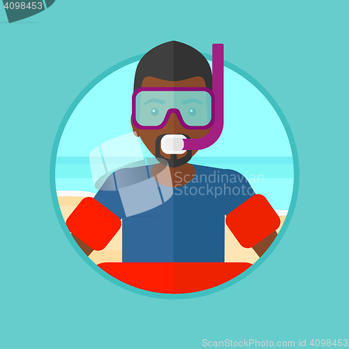 Image of Man with snorkeling equipment on the beach.