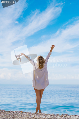 Image of portrait of young pretty woman looking to the ocean 