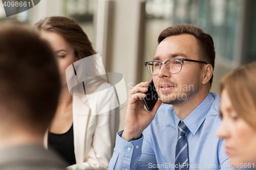 Image of businessman calling on smartphone at office