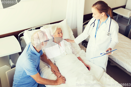 Image of senior woman and doctor with clipboard at hospital