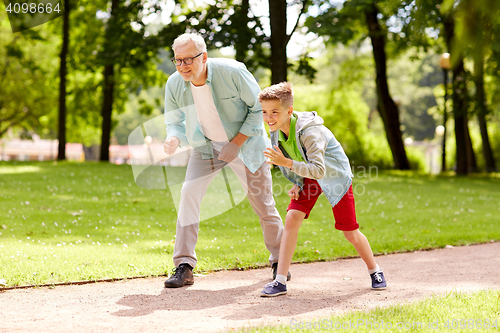 Image of grandfather and grandson racing at summer park