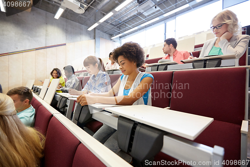 Image of group of students with notebooks at lecture hall