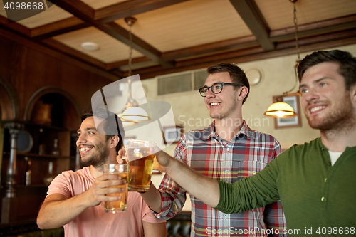 Image of happy male friends drinking beer at bar or pub