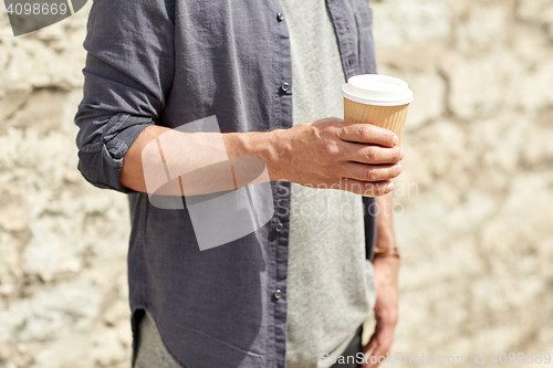 Image of close up of man with paper coffee cup on street