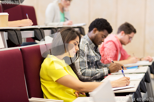 Image of group of students with notebooks in lecture hall